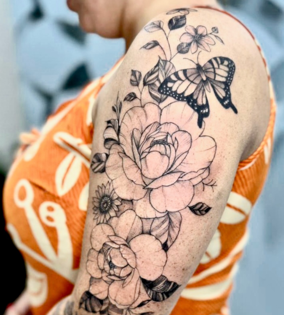 Tatuagem floral com borboleta no braço