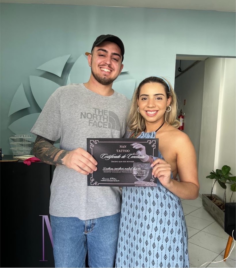 Entrega de certificado de conclusão a um aluno da NAN Tattoo